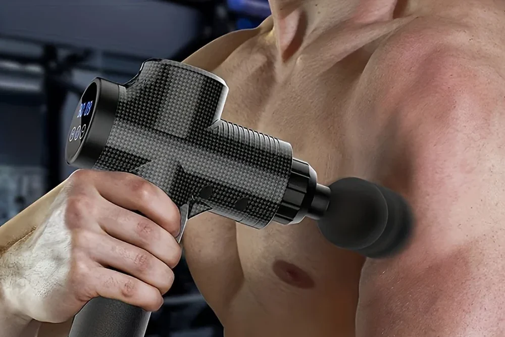 Pistolet de massage Percuva appliqué sur le muscle de l’épaule, écran allumé